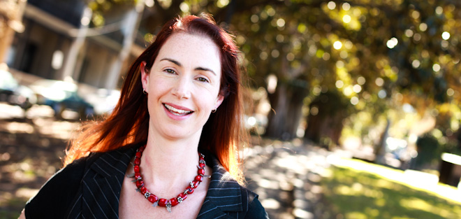 louise alley head and shoulders standing smiling with trees and park behind